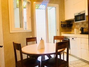 Une cuisine compacte comprenant une table et des chaises, un four à micro-ondes et un lave-vaisselle.