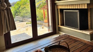A room with a sliding glass door leading to an outdoor area, a fireplace, and a wooden floor.