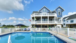A two-story house with a swimming pool, a deck, and a white fence. - Bayfront home with private pool on Slaughter Beach! (Milford)
