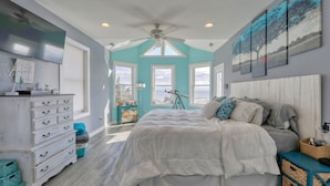 A bedroom with a bed, dresser, and artwork on the walls. - Bayfront home with private pool on Slaughter Beach! (Milford)