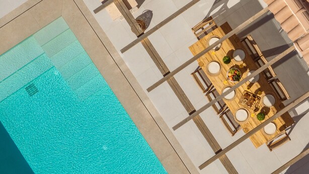 Vista aérea de un área de piscina con una zona de comedor.
