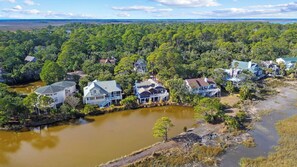 A residential area with houses along a riverbank, surrounded by dense forest. - Lake View, Golf Cart Included - 122 Sand Piper (Fripp Island)