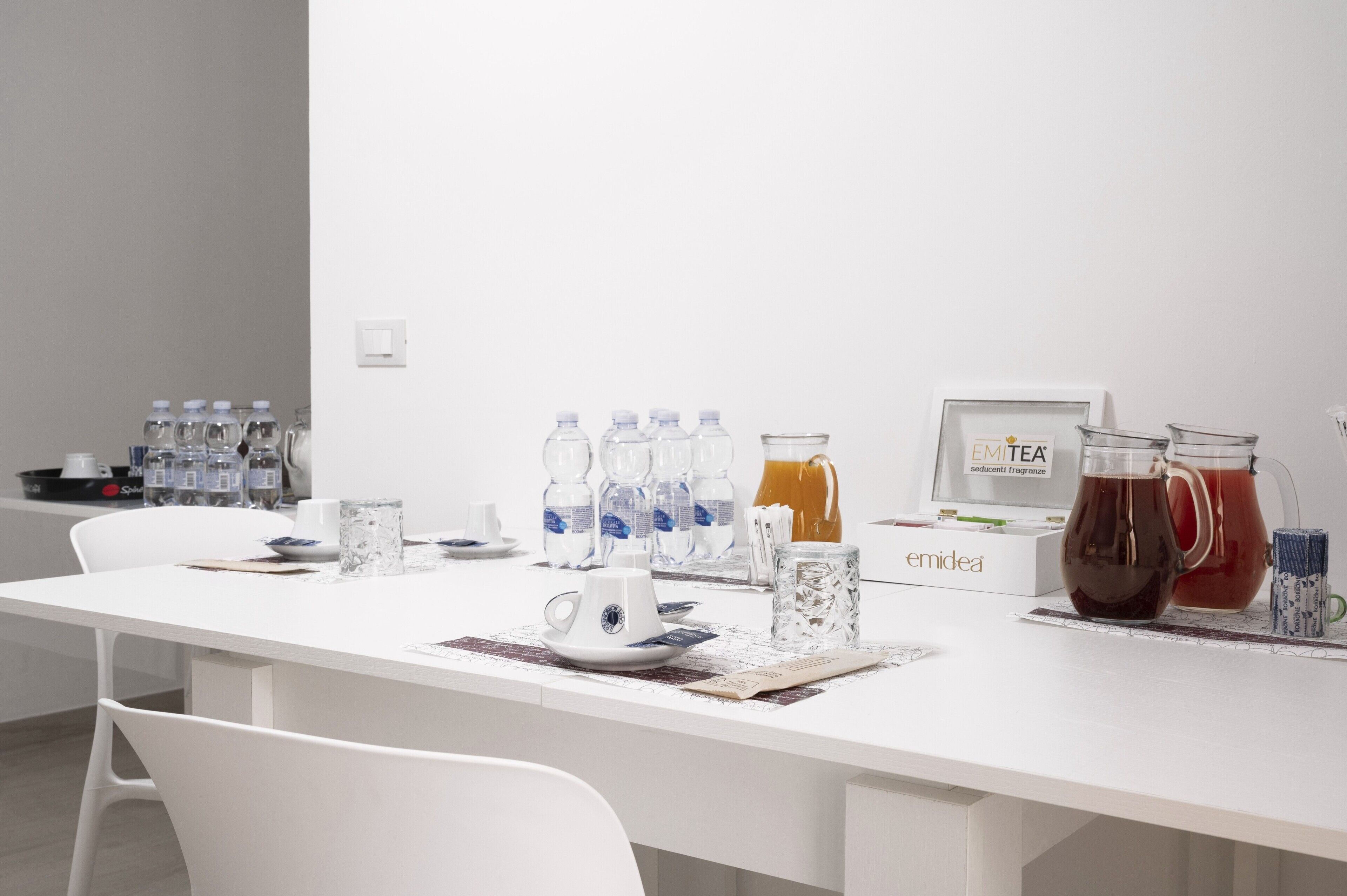 Ein Konferenztisch mit Wasserflaschen, einer Kaffeemaschine und einer Tee-Station.