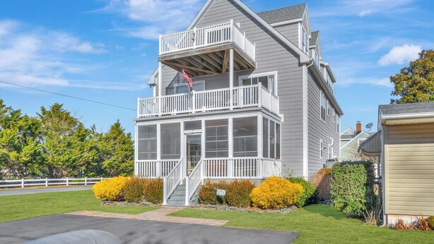 A two-story house with a balcony and a covered front porch. - Harbor View by Seaside Vacations & Sales (Ocean City)