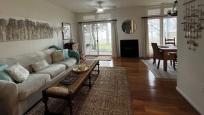 A living room with a sofa, coffee table, and fireplace. - One bedroom Apartment in Rehoboth Beach (Rehoboth Beach)