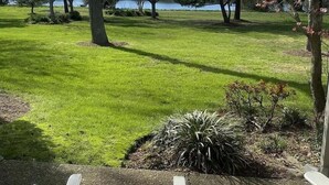 A park with a grassy area, trees, and a body of water in the background. - One bedroom Apartment in Rehoboth Beach (Rehoboth Beach)