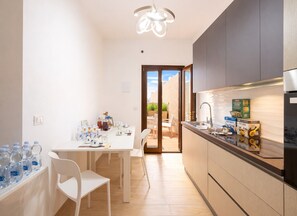 A modern kitchen with a dining area, a built-in oven, and a view to the outside.