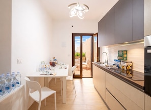 Une cuisine moderne avec un coin repas, un four encastré et une vue sur l’extérieur.