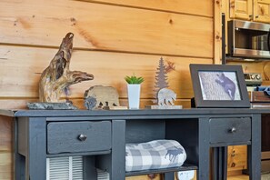 A wooden cabin interior with a desk displaying a framed picture, a small potted plant, and various decorative items. - Relaxing Cabin Hot Tub Game Room Near Attractions (Sevierville)