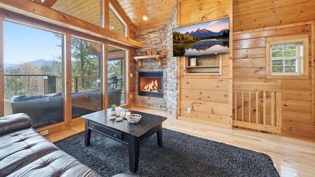 Una habitación acogedora con chimenea, ventanas amplias y una pared de piedra.