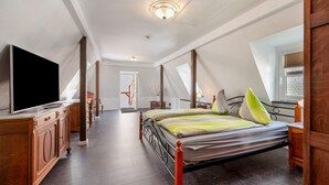 A bedroom with a large bed, a television, and a wooden dresser. - Top Moselle Apartment: Stunning Panoramic Views (Traben-Trarbach)