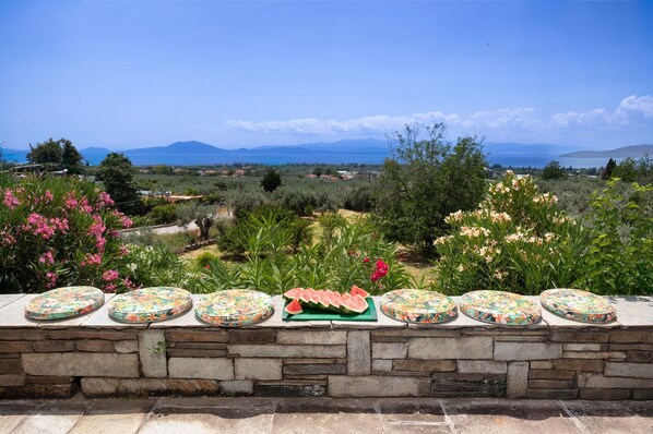 A stone wall with a series of round, colorful tiles and a watermelon on a green tray. - Villa Annelies Pelion (Kato Lechonia)