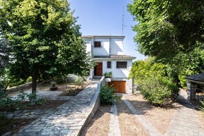 A two-story house with a stone pathway leading to the entrance. - Villa Annelies Pelion (Kato Lechonia)