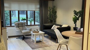 Una sala moderna con sofá, sillón y mesa de comedor.