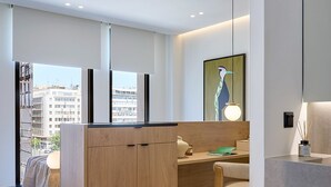A modern kitchen with wooden cabinets, a dining area, and a view of the city. - Executive Apartment by Fasma Suites (Pireas)