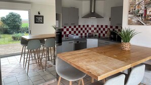 Una cocina moderna con comedor, ventanas amplias y vistas al exterior.