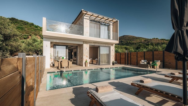 A modern two-story house with a swimming pool, wooden deck, and outdoor seating area. - J&K Villa with private pool (Zakynthos)