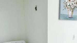 A white washing machine in a room with white walls and a tiled floor. - 2-bedrooms next to Grace Bay (Grace Bay)