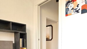 A neatly made bed with a blue towel, a bedside lamp, and a bookshelf. - Renovated flat with panoramic view-Casa Olivazzo (Chiusi)