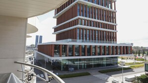 Ein mehrstöckiges Gebäude mit moderner Architektur, das ein markantes 'CRUISE'-Schild im Erdgeschoss zeigt.