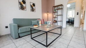 A living room with a green sofa, a coffee table, and a bookshelf. - Philomena Apartment by Ionian Luxury (Kerkira)