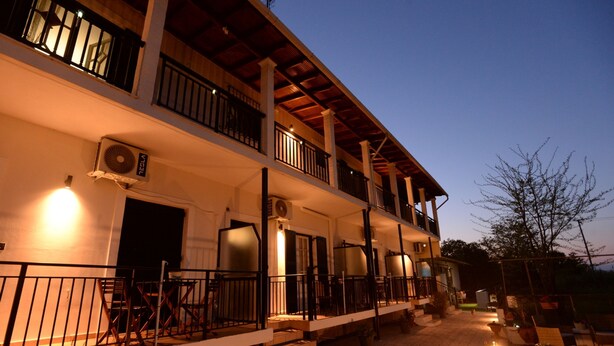 A two-story building with balconies, outdoor seating, and a fire extinguisher. - Philomena Apartment by Ionian Luxury (Kerkira)