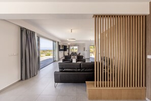 Ein modernes Wohnzimmer mit Sofa, Essbereich und Blick ins Freie.