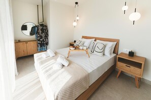 A modern bedroom with a large bed, bedside tables, a wooden wardrobe, and a mirror. - Aiolia Villa in Rhodes (Rhodes)