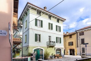 A multi-story building with a green door, a balcony, and a sign indicating a nearby location. - Desenzano Suites - Equiseto by Wonderful Italy (Desenzano del Garda)