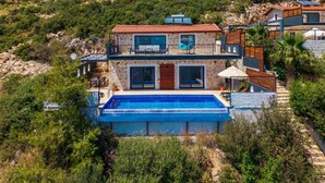 A two-story stone house with a swimming pool, surrounded by greenery and hills. - Villa Elvin in İslamlar Köyü (İslamlar Köyü)