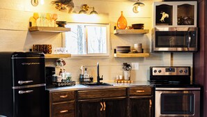 A kitchen with a refrigerator, stove, microwave, and wooden cabinets. - The Silo On 16 (Graham)