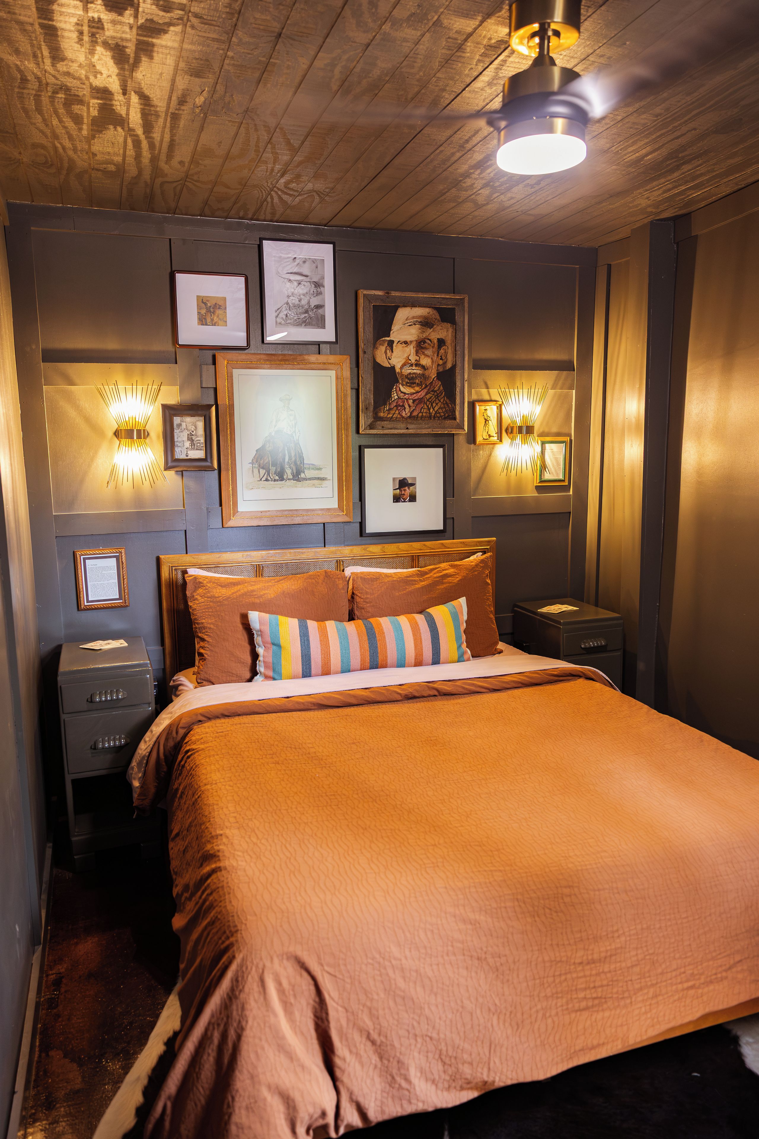 Ein Schlafzimmer mit einem großen Bett, einem Nachttisch, einer Kommode und Wandleuchten.