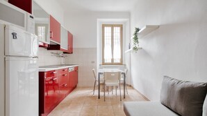 A compact kitchen with a dining area, a window, and a sofa. - The Light Flat Bonghi is a bright and welcoming apartment just steps from Bocconi University, ideal for seating up to 6 people.It has two bedrooms and a living room with a sofa bed, perfect for relaxing moments after a day in the city.The rooms are well- (Milan)