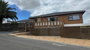 A modern two-story house with a brick facade, a garage, and a gated driveway. - Plattekloof guest house (Cape Town)
