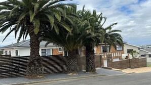 A residential area with houses, palm trees, and a gated fence. - Plattekloof guest house (Cape Town)
