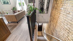 A staircase with a brick wall on one side and a wooden floor on the other.