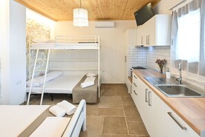 A compact kitchen with a sink, cabinets, and a wooden countertop. - Studio with Garden View (Fourka)