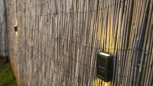 Una recinzione in bambù con una telecamera di sicurezza.