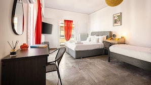 Ein modernes Hotelzimmer mit Bett, Schreibtisch, Stuhl und Fernseher.
