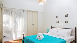 Ein Schlafzimmer mit Bett, Kleiderschrank und einer Tür mit leichtem Vorhang.