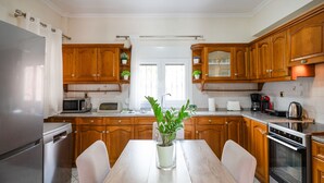 Eine moderne Küche mit Holzschränken, Edelstahlgeräten und einer zentralen Kochinsel mit Blumentopf.
