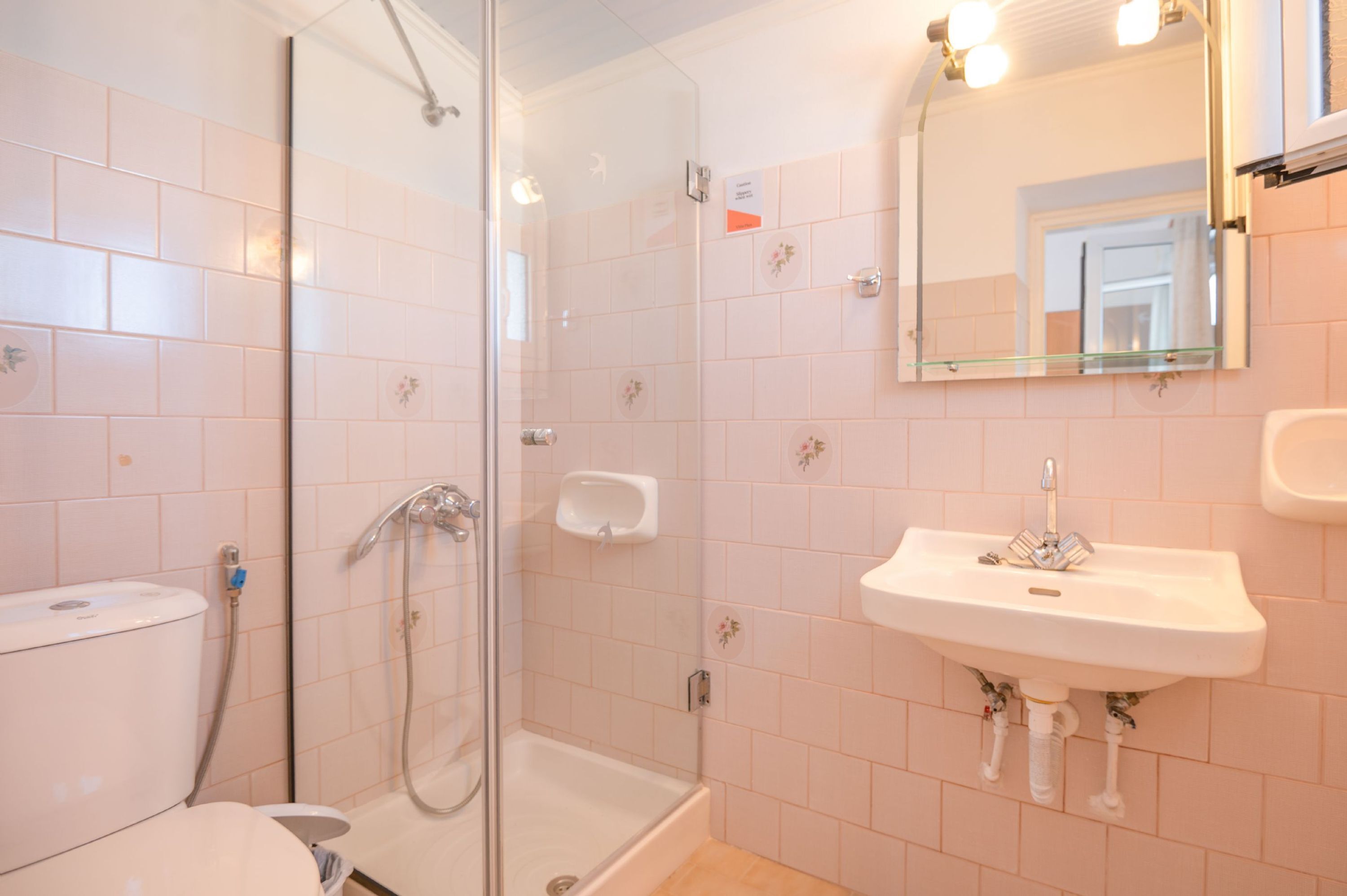Ein Badezimmer mit Duschkabine, Waschbecken und Toilette.