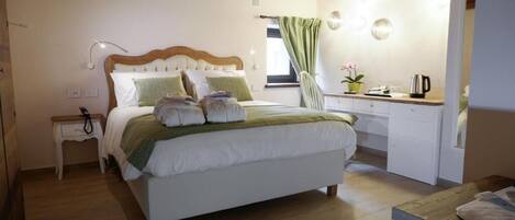 Une chambre à coucher avec un lit, une table de chevet et un bureau avec une chaise.