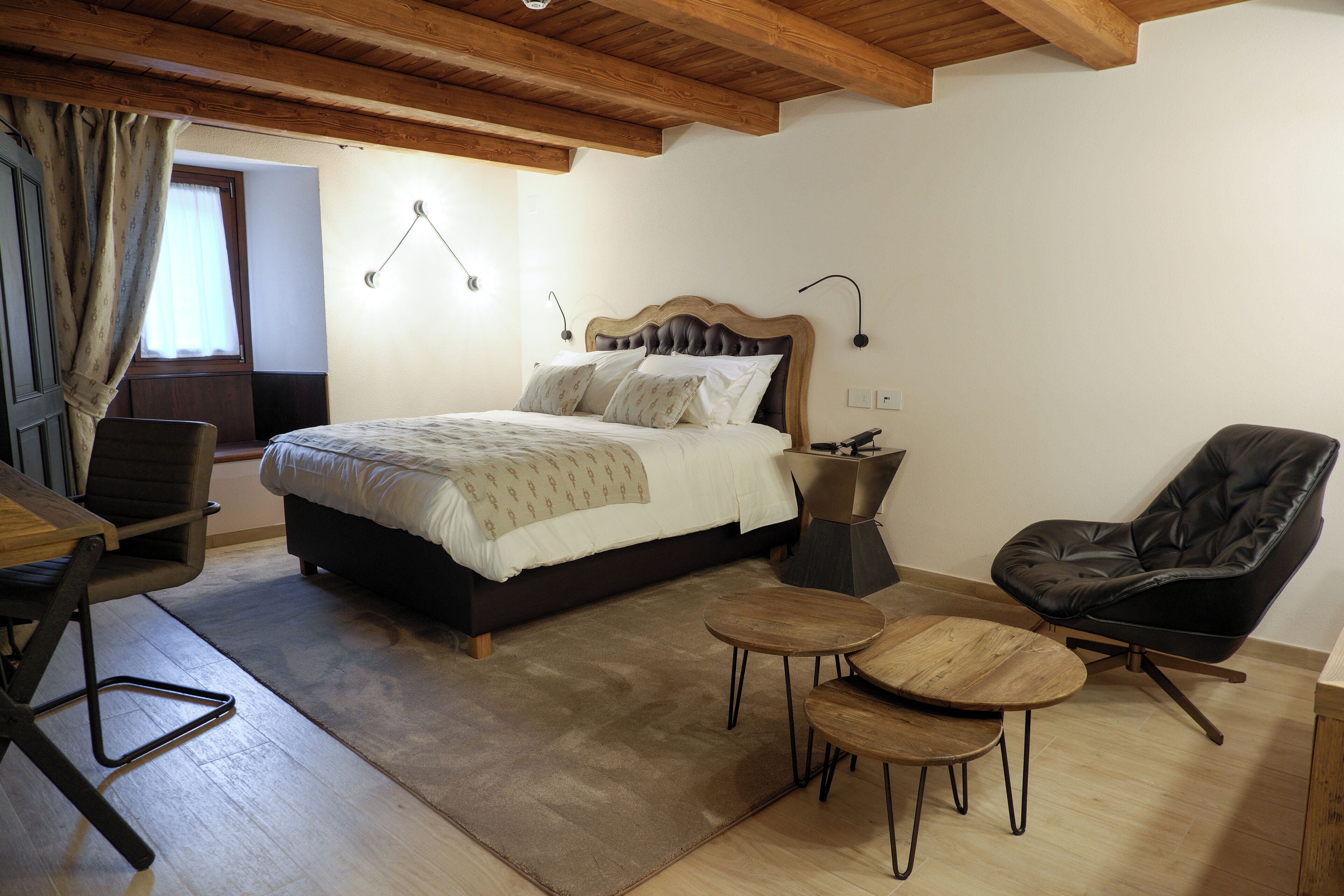 Une chambre à coucher comprenant un lit, un bureau, deux chaises et une petite table.