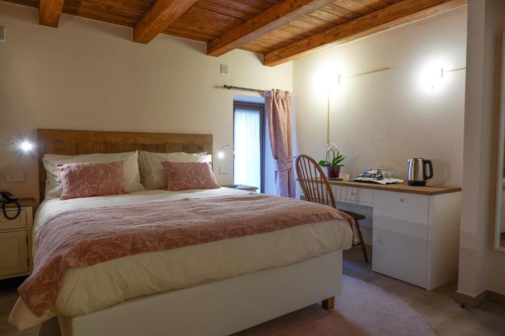 Ein Schlafzimmer mit Bett, Nachttisch und Schreibtisch mit Stuhl.