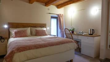 Ein Schlafzimmer mit Bett, Nachttisch und Schreibtisch mit Stuhl.