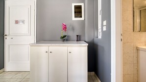 A bathroom with a white sink, a mirror, and a door with a 'No Smoking' sign. - Sunny penthouse in Koukaki - Next to  Acropolis (Athina)