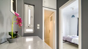 A modern bathroom with a marble countertop, a potted orchid, and a visible shower area. - Sunny penthouse in Koukaki - Next to  Acropolis (Athina)
