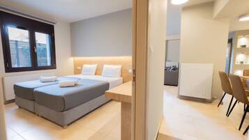 Un dormitorio moderno con una cama doble, mesitas de noche, un escritorio y una silla.