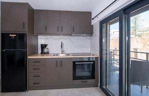 Eine moderne Küche mit Backofen, Kaffeemaschine und Kühlschrank.